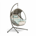 Hanging egg chair with cushioned seating and steel frame in grey and mint color